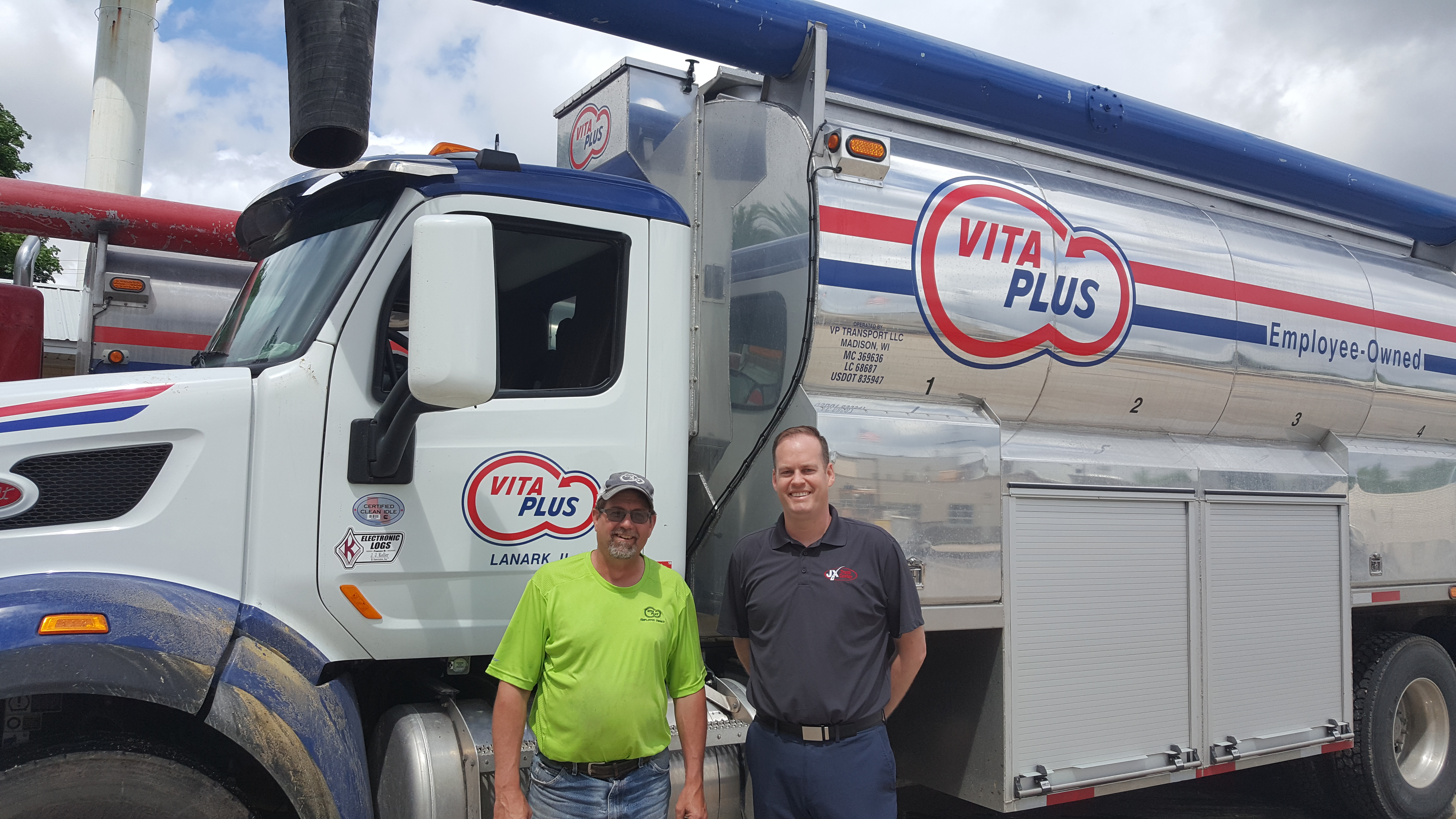 jx employee poses with vita plus truck driver and truck