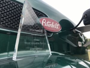 sourcewell Most Valuable Partner Award for extraordinary truck sales to jx enterprises sourcewell award presented on peterbilt truck