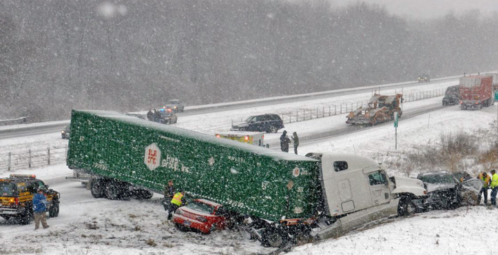 White truck with green trailer in winter weather safety failure accident on highway